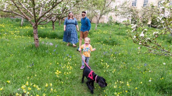 A family with their dog walking in the garden at Nunnington Hall, North Yorkshire